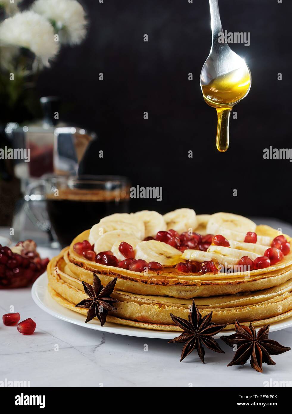 Honey pouring over stack of pancakes / crepes Stock Photo