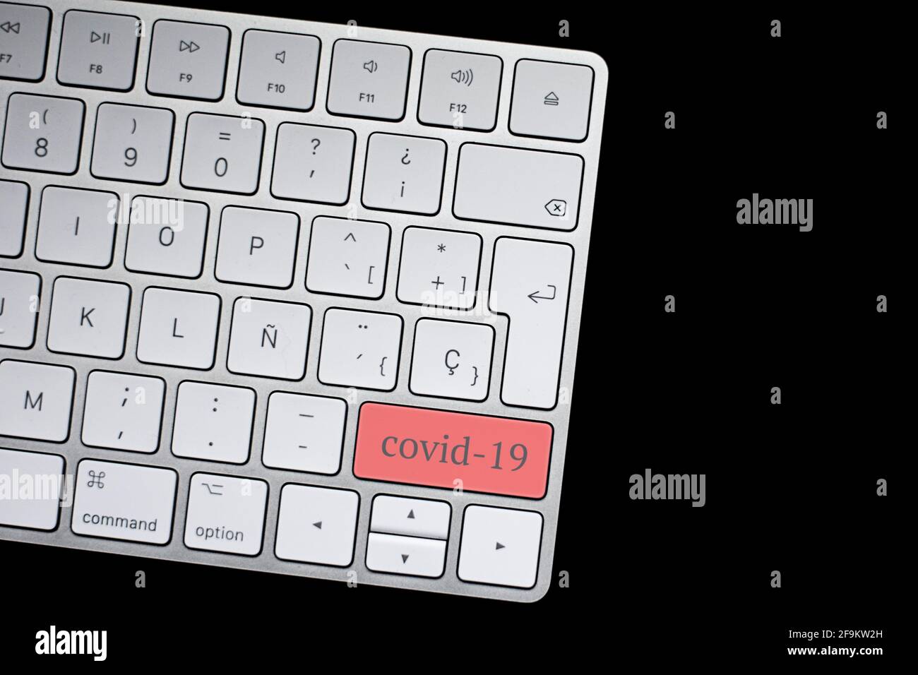 Keyboard with the red covid-19 button. Concept for any illustration of teleworking or telecommuting, self-employed, home workers by coronavirus. Stock Photo