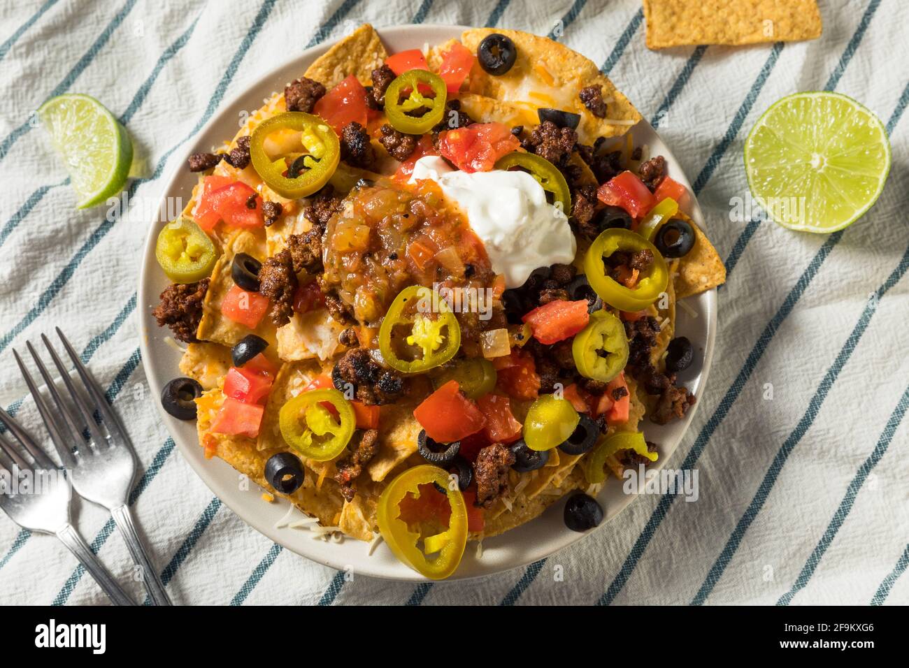 Homemade Cheesy Beef Nachos with Olives and Jalapenos Stock Photo