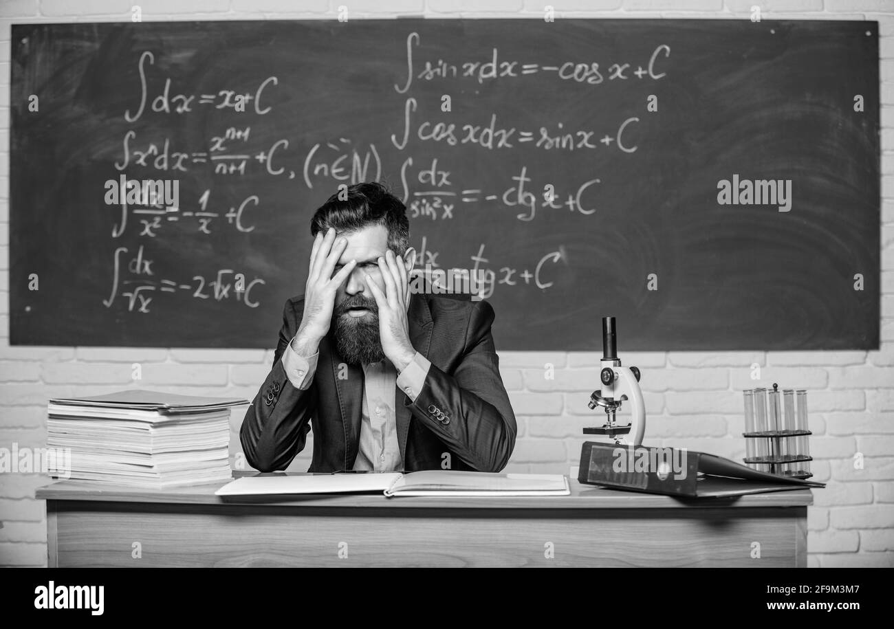 Teaching dumb students. No hope for better. Tired and exhausted. Teacher mature man. Fed up. Difficult work. Emotional burnout. Teacher give up. Hate Stock Photo