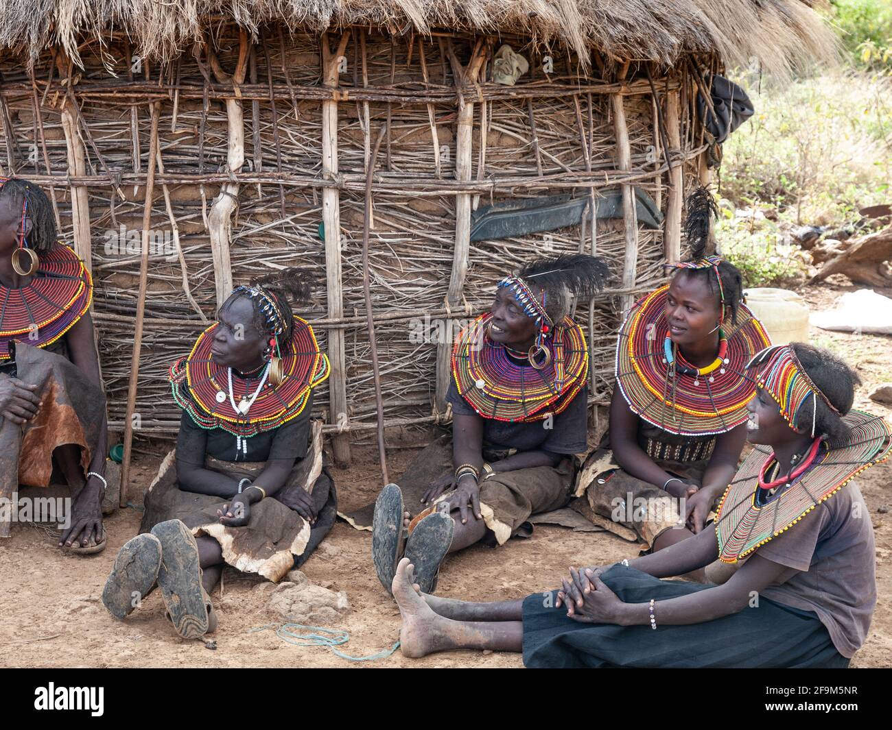 Native women in traditional garb, posing in village. The Pokot people ...