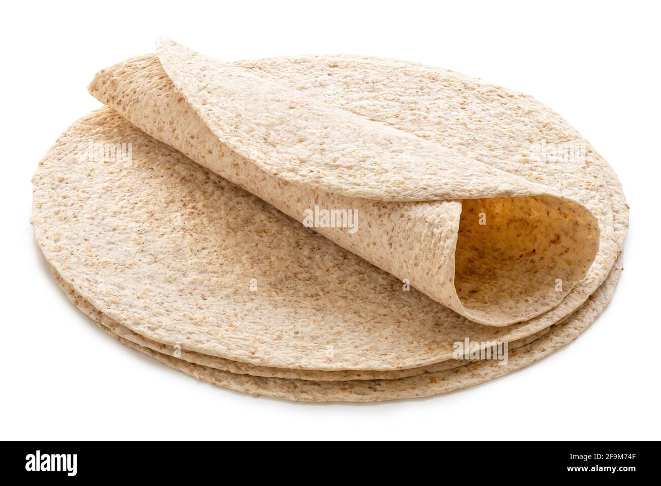 Rolled up tortilla on top of a stack of plain spelt and oat tortilla wraps isolated on white. Stock Photo