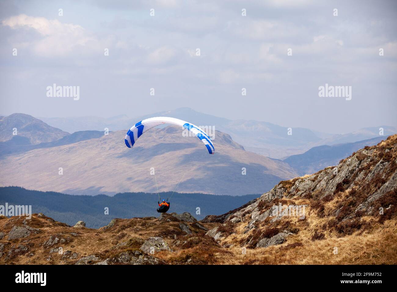 A paraglider flying in the Scottish hills near the Munro Stùc a' Chròin