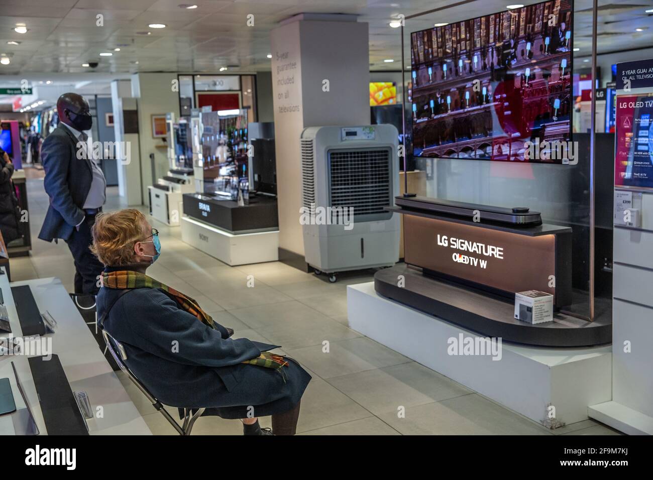 People watch the Duke of Edinburgh funeral on national television whilst shopping inside a John Lewis department store, Oxford Street, London, UK Stock Photo