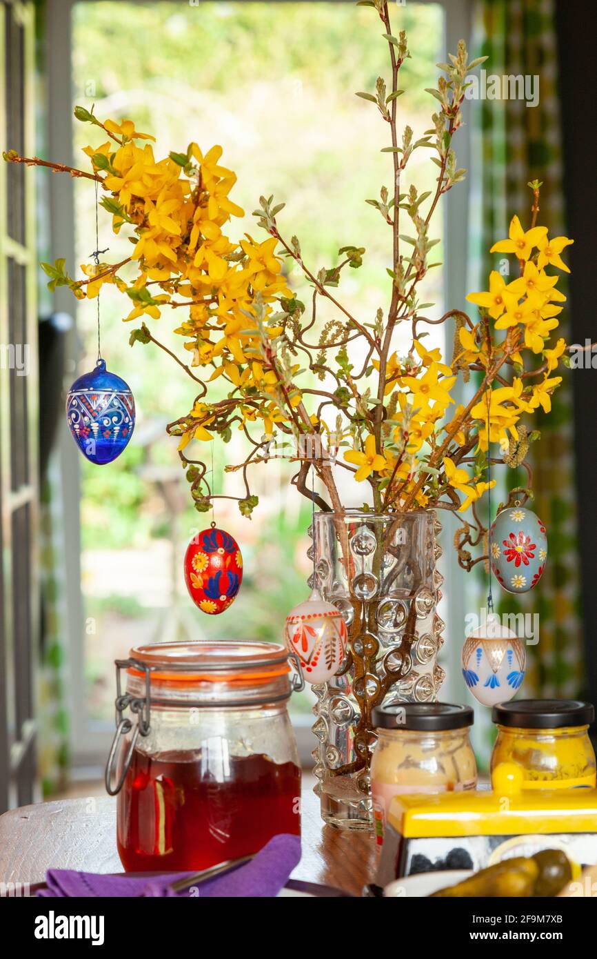 Hanging hand painted easter eggs from a branch as table decorations. Stock Photo