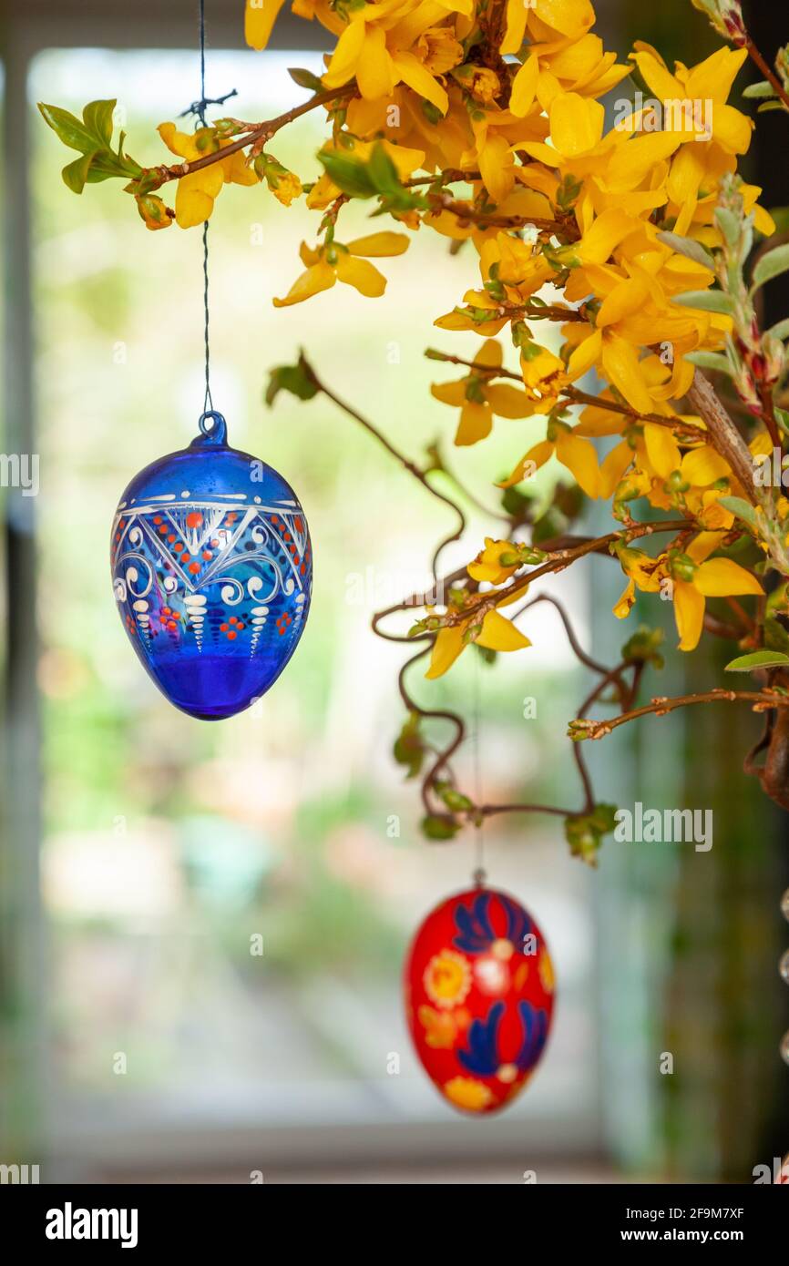 Hanging hand painted easter eggs from a branch as table decorations. Stock Photo