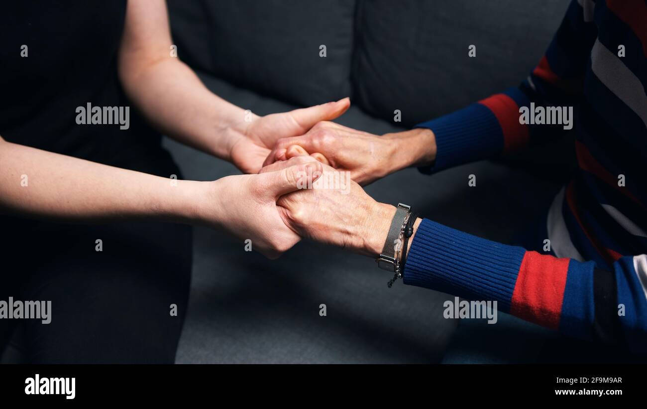 Young person holding hands of an elderly woman. High quality photo Stock Photo