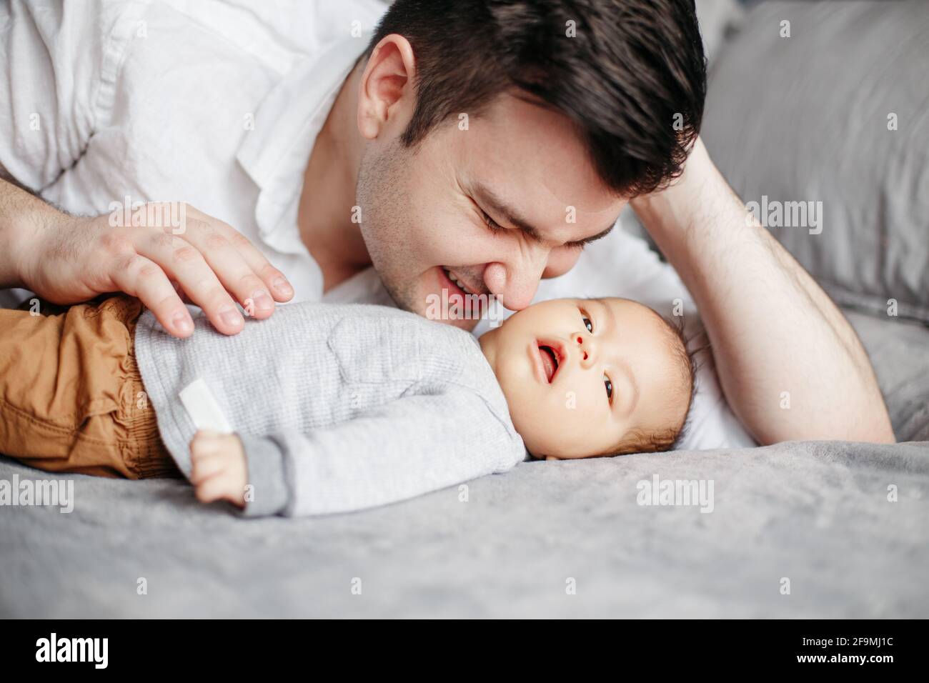 Closeup of happy smiling dad father kissing newborn baby boy son. Stock Photo