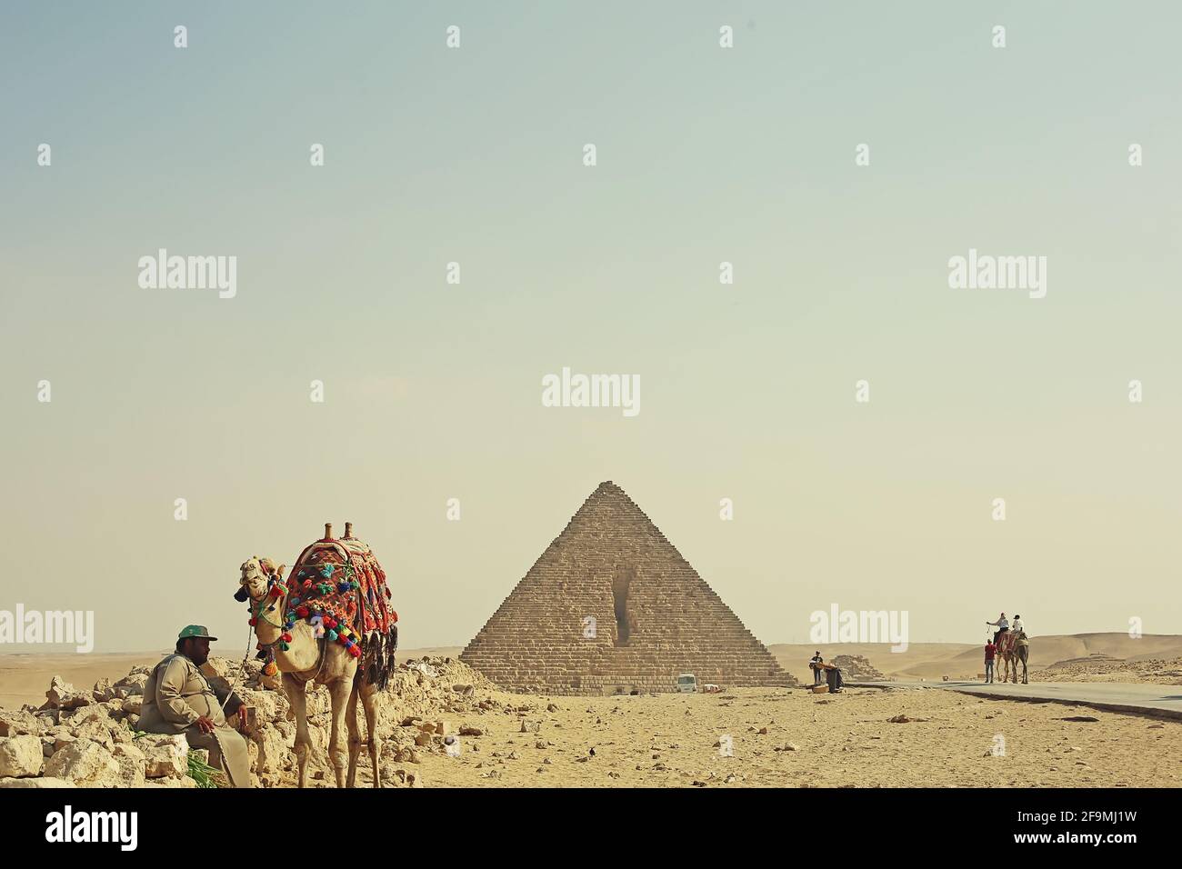 Egyptian desert landscape with pyramid, camels and men, Giza, Cairo Stock Photo