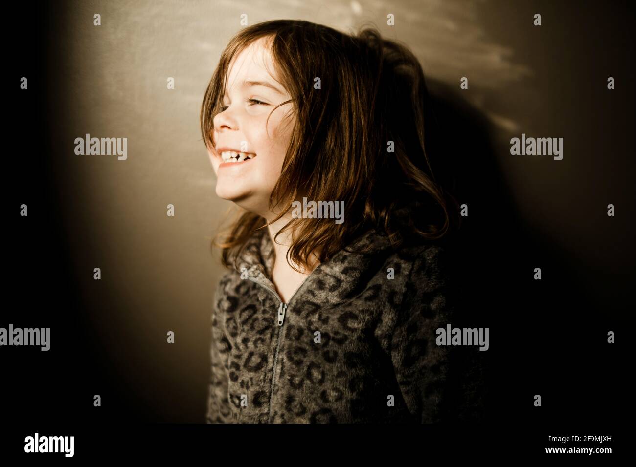 Young girl wearing a leopard pajamas laughing in the afternoon Stock Photo