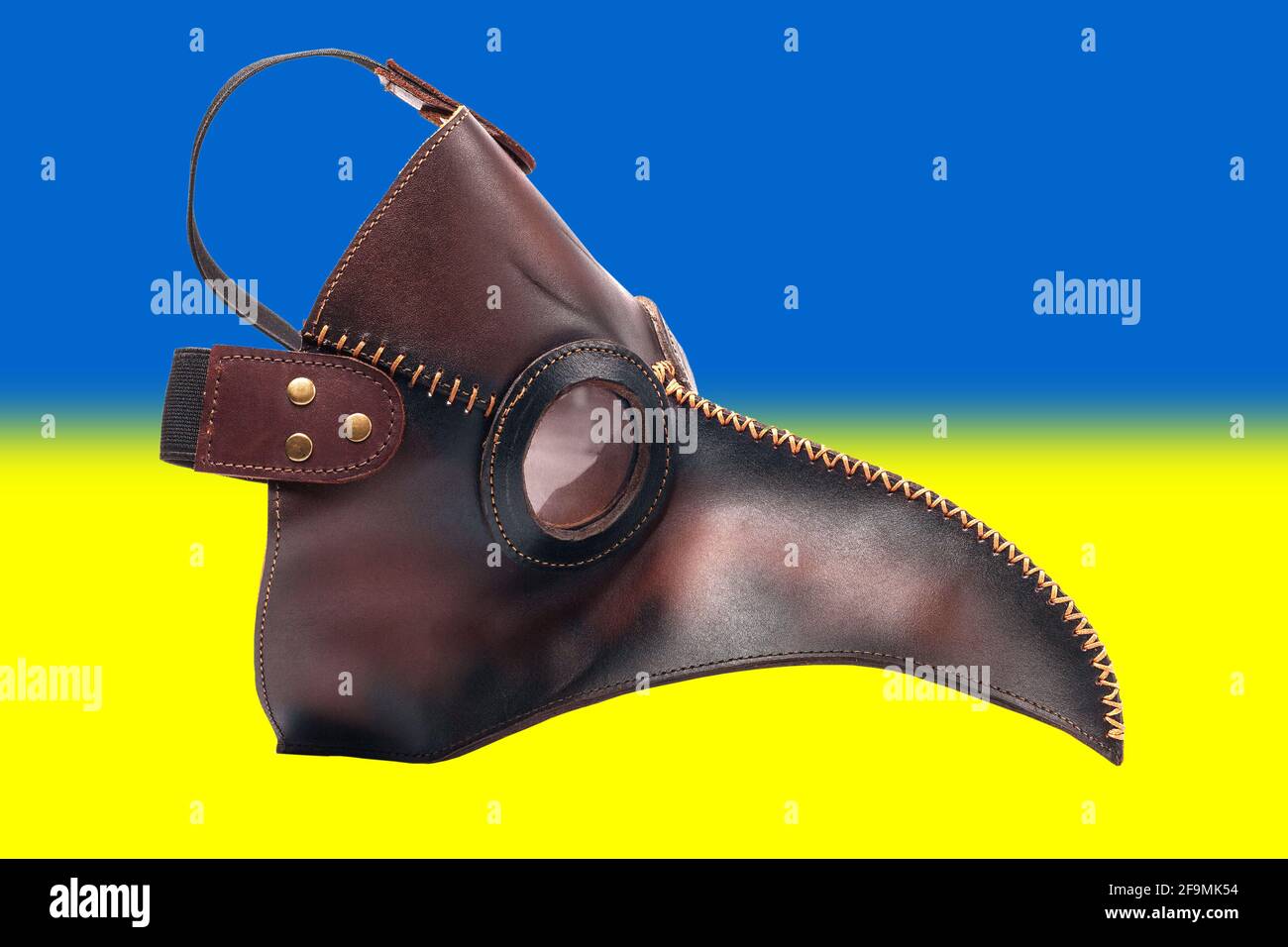 Protective medical mask of the plague doctor against the background of the flag of Ukraine. The concept of a mask mode for residents of the country and tourists during a pandemic. Stock Photo