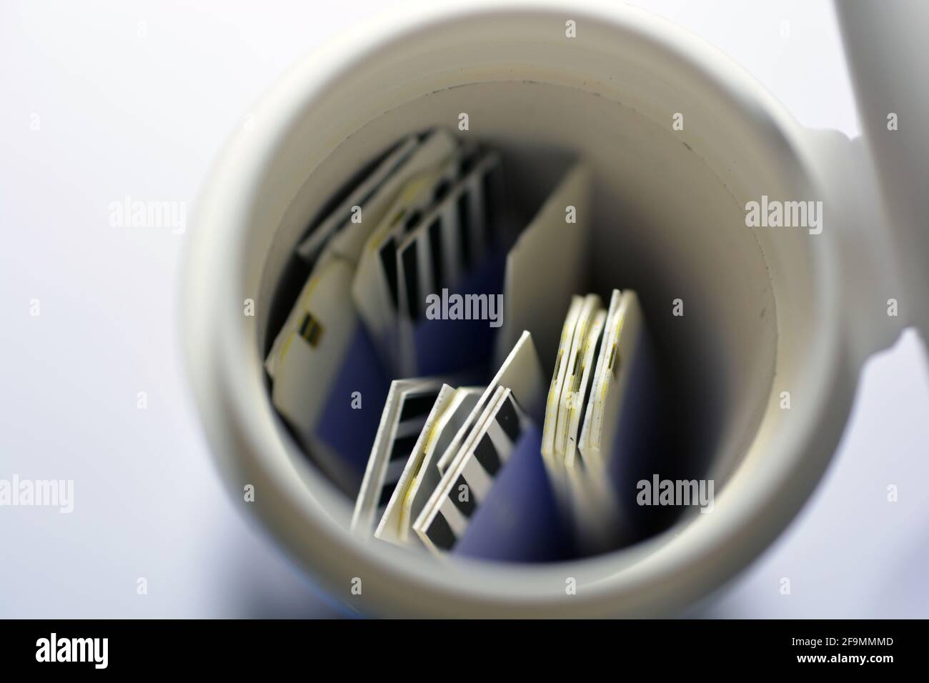 A small container with test strips for diabetic patients that measures random blood sugar RBS (blood glucose) in a glucometer at home isolated on whit Stock Photo