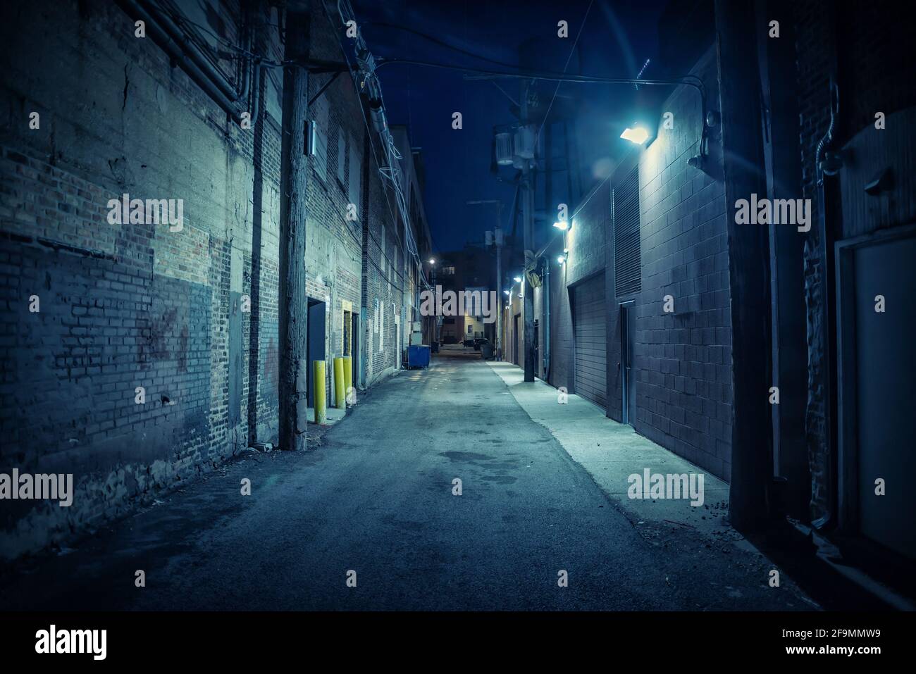 Dark and eerie urban city alley at night Stock Photo