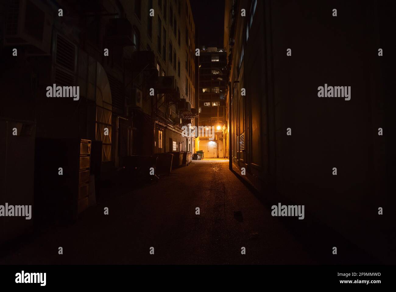 Dark and eerie urban city alley at night Stock Photo