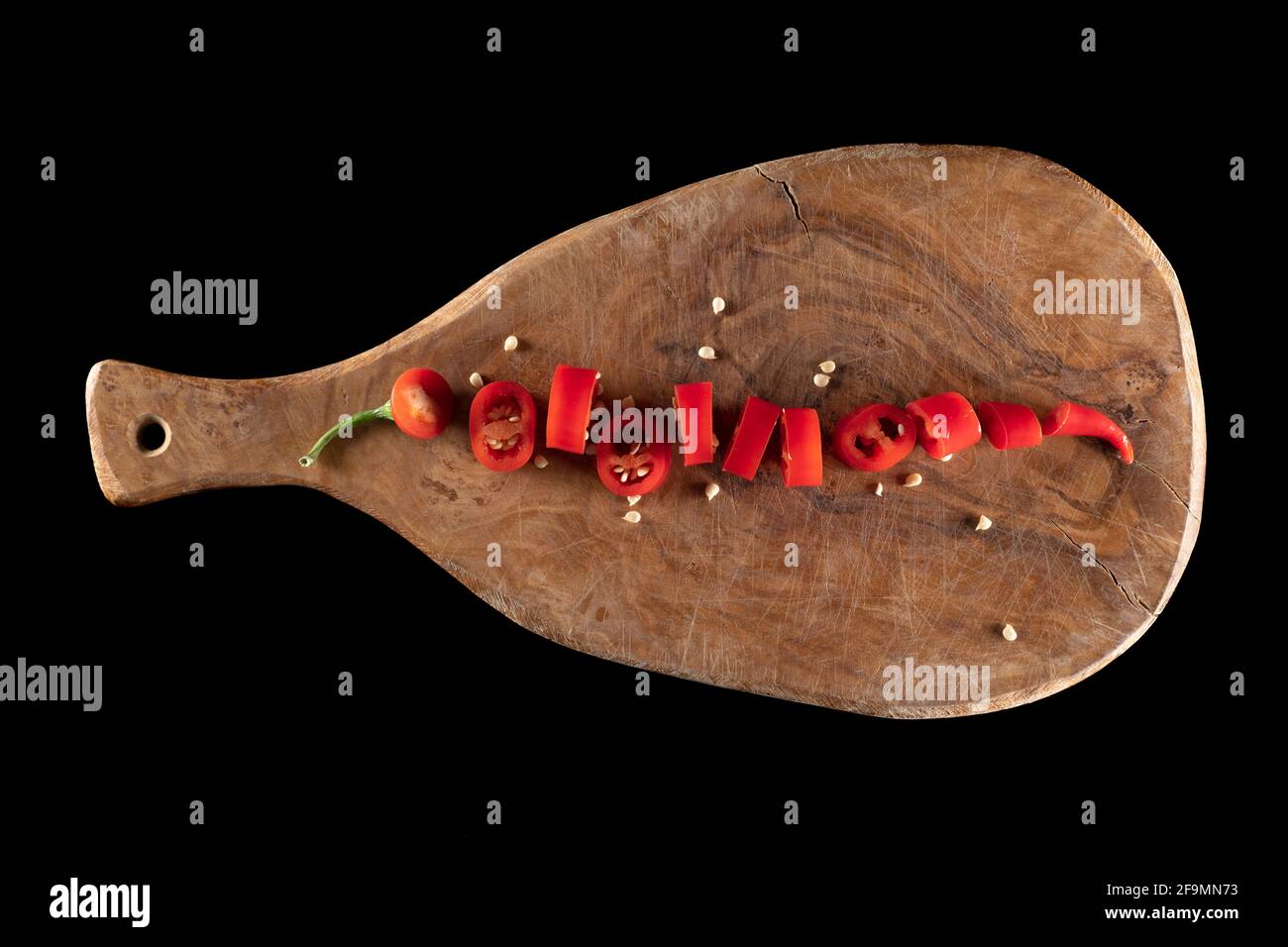 Cayenne, long red chili peppers on cutting board Stock Photo