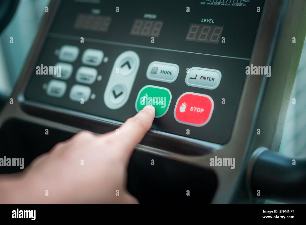 Start running Hand pressing start button on treadmill control panel