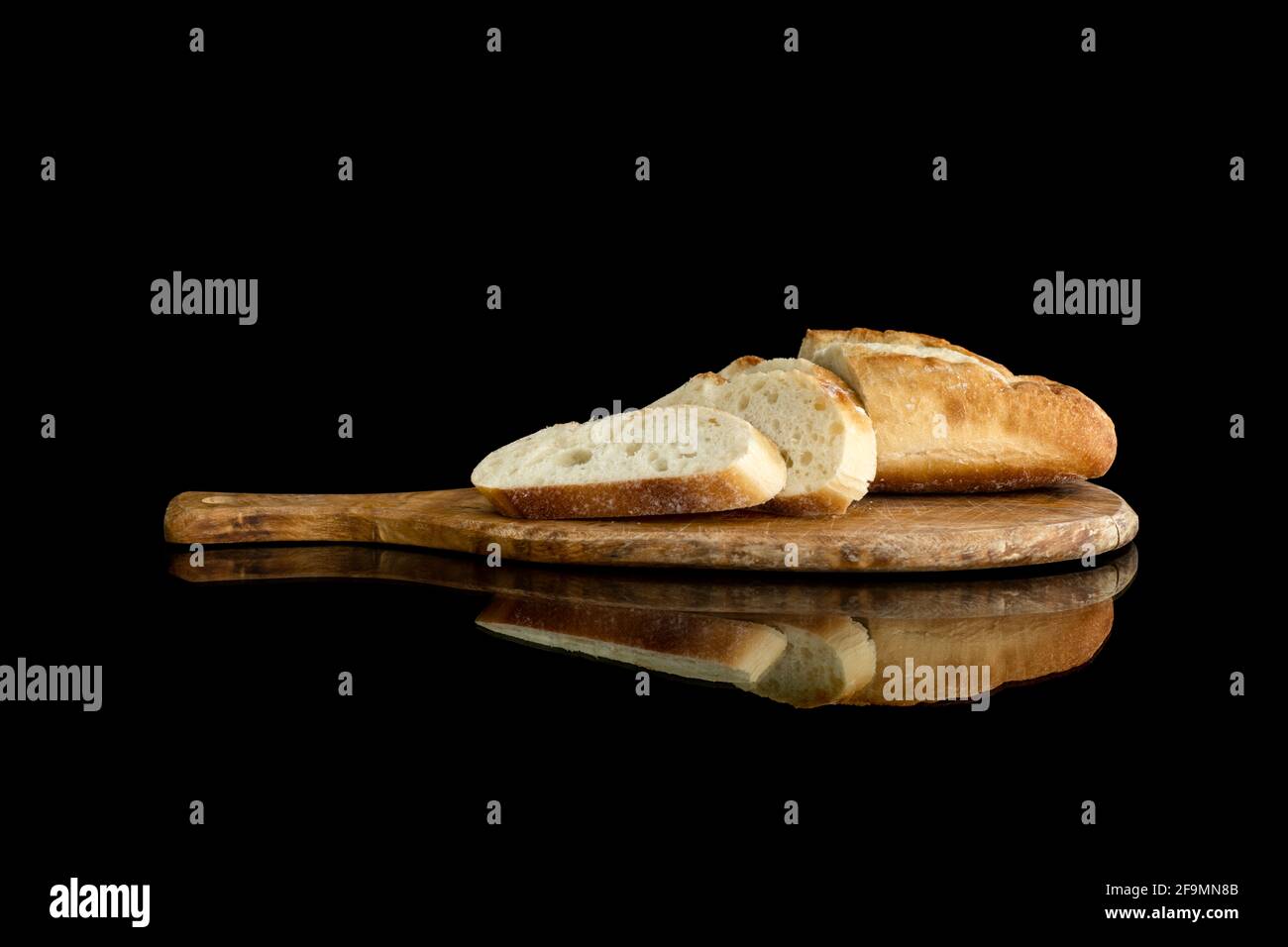 Image of bread on cutting board with reflection on dark background Stock Photo