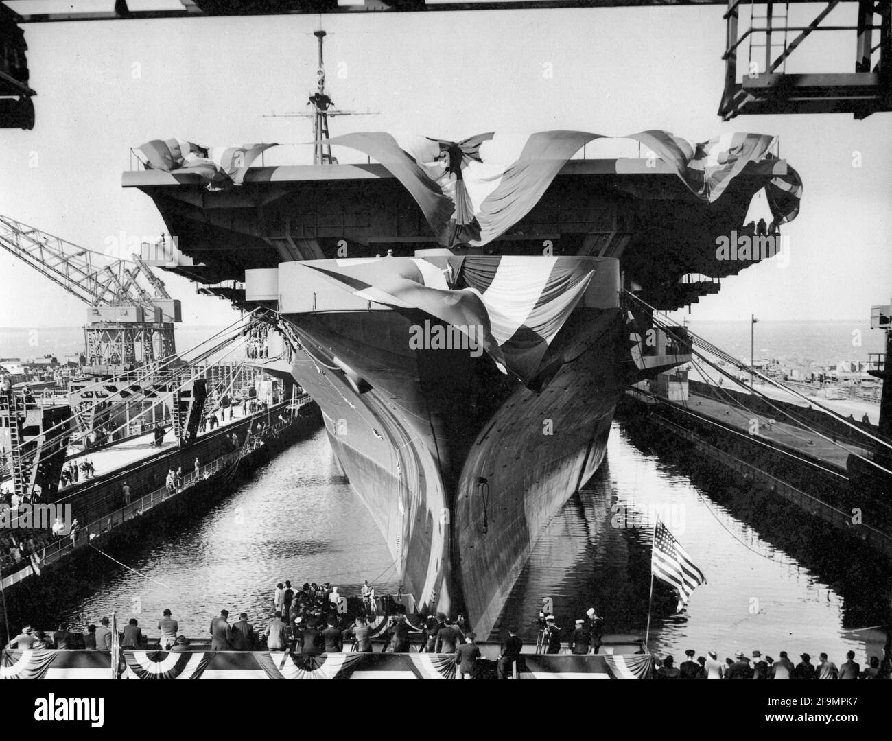Overall view of the USS Midway, 45,000 ton aircraft carrier, shown during launching ceremonies at the Newport News Shipbuilding and Dry Dock Company. Captain J. F. Bolder, former aide to Artemus L. Gates, Assistant Secretary of the Navy, has been placed in command of the vessel. Among the distinguished guests present at the launching were: Secretary Gates; Vice Admiral Patrick N. L. Bellinger, Air Force Commander of the Atlantic Fleet; Rear Admiral Albert C. Read, first man to pilot an airplane across the Atlantic, now Fleet Air Commander of the Norfolk Naval Air Station; and Rear Admiral E. L Stock Photo