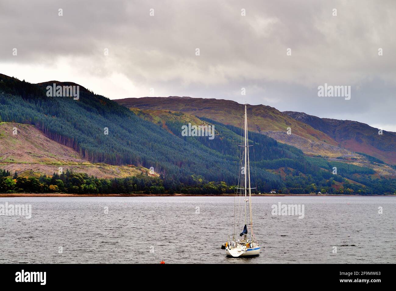 Shiel Bridge, Highlands, Scotland, United Kingdom. A solitary sailboat sits anchored in Loch Duich among the Highlands. Stock Photo