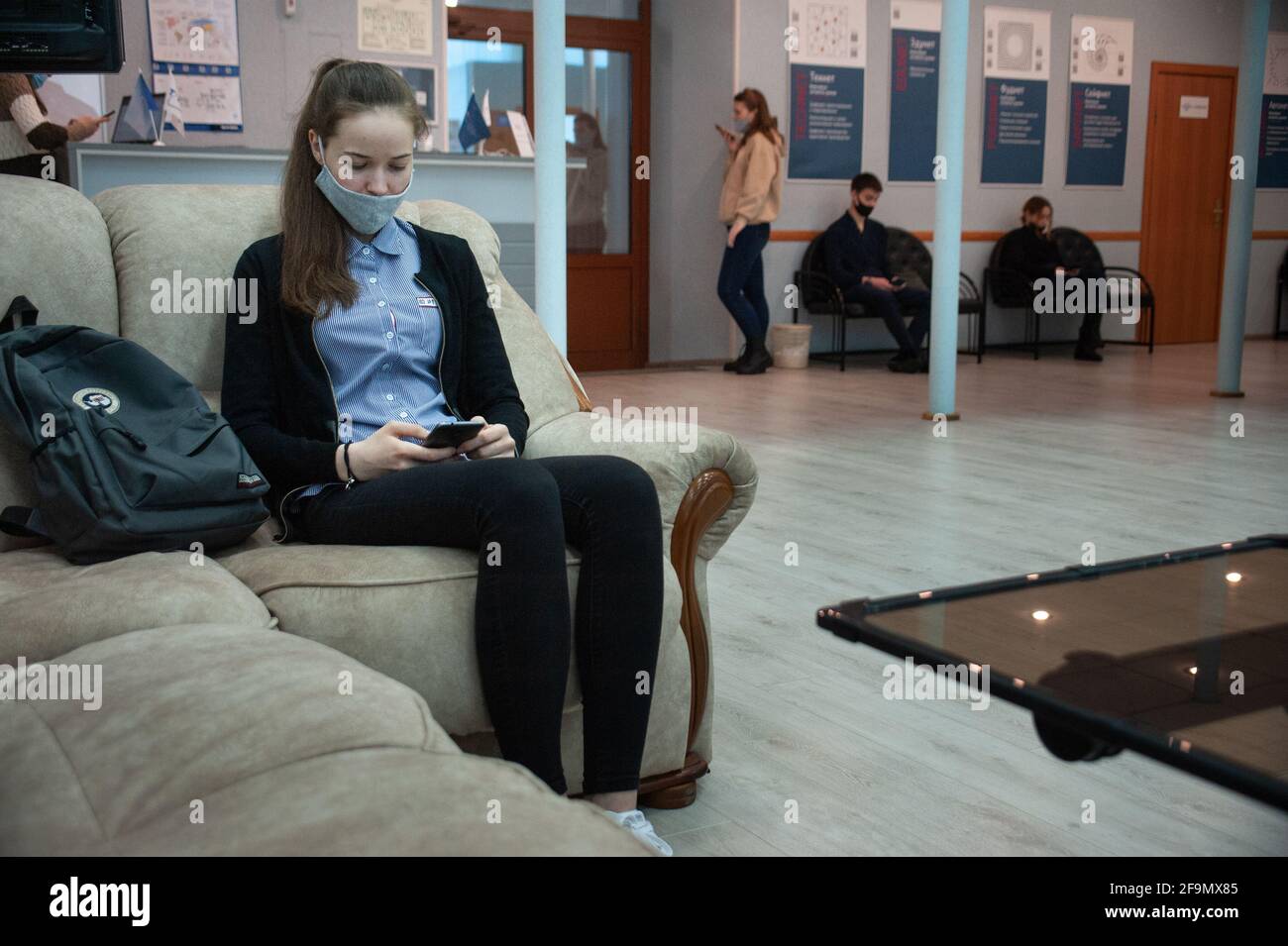 Tambov, Russia. 19th Apr, 2021. A girl wearing a face mask sits in one ...