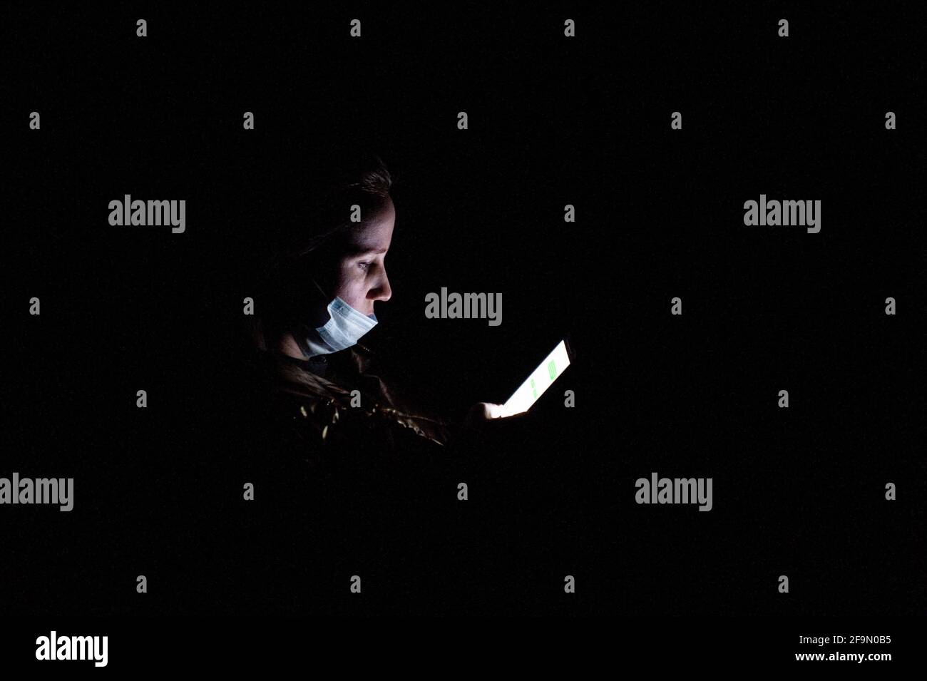 Tambov, Russia. 10th Mar, 2021. A woman wearing a facemask uses a smartphone in an apartment during a power outage in a residential building on Internatsionalnaya Street in Tambov. (Photo by Lev Vlasov/SOPA Images/Sipa USA) Credit: Sipa USA/Alamy Live News Stock Photo