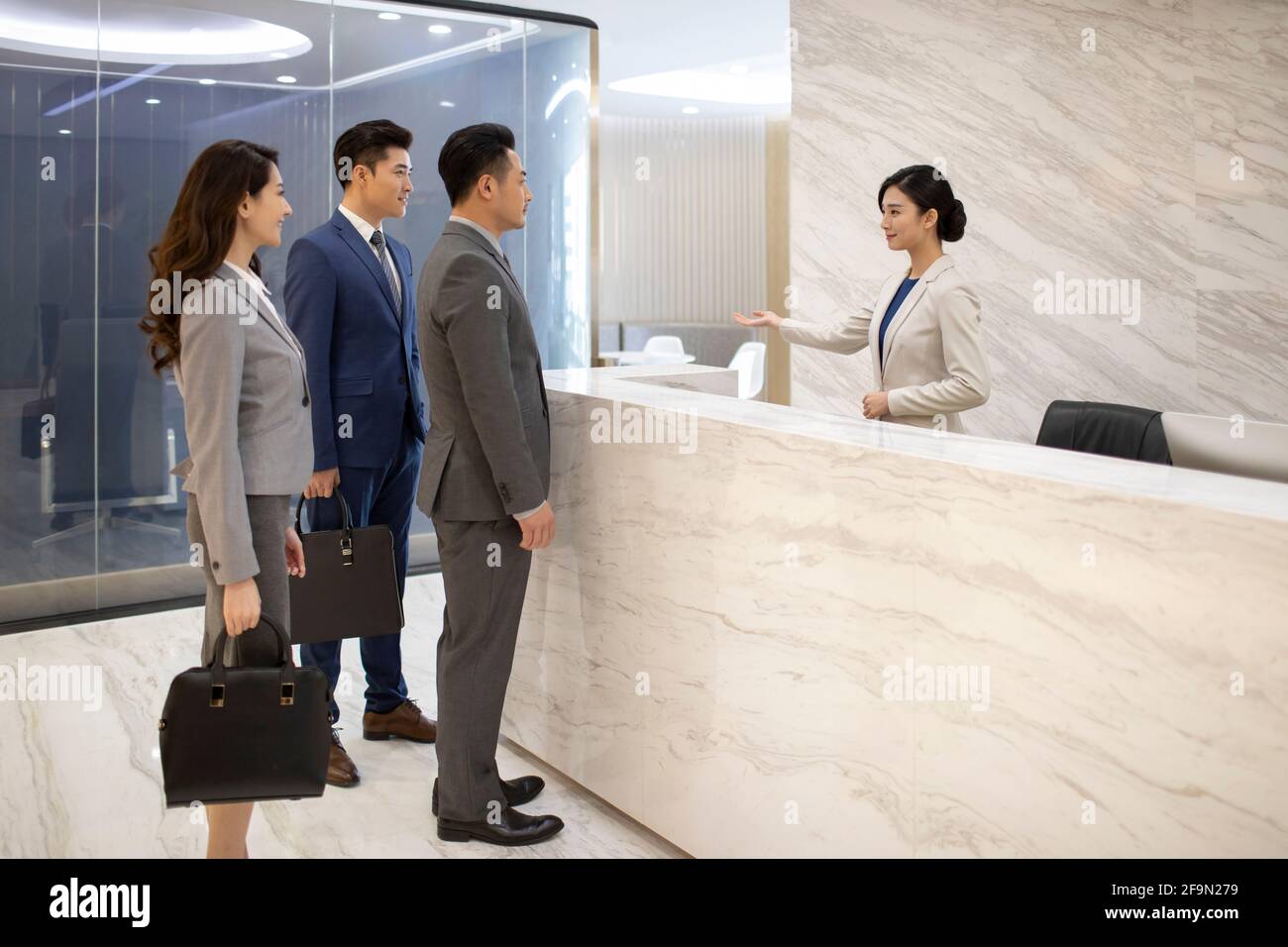 Successful business people talking with receptionist Stock Photo Alamy
