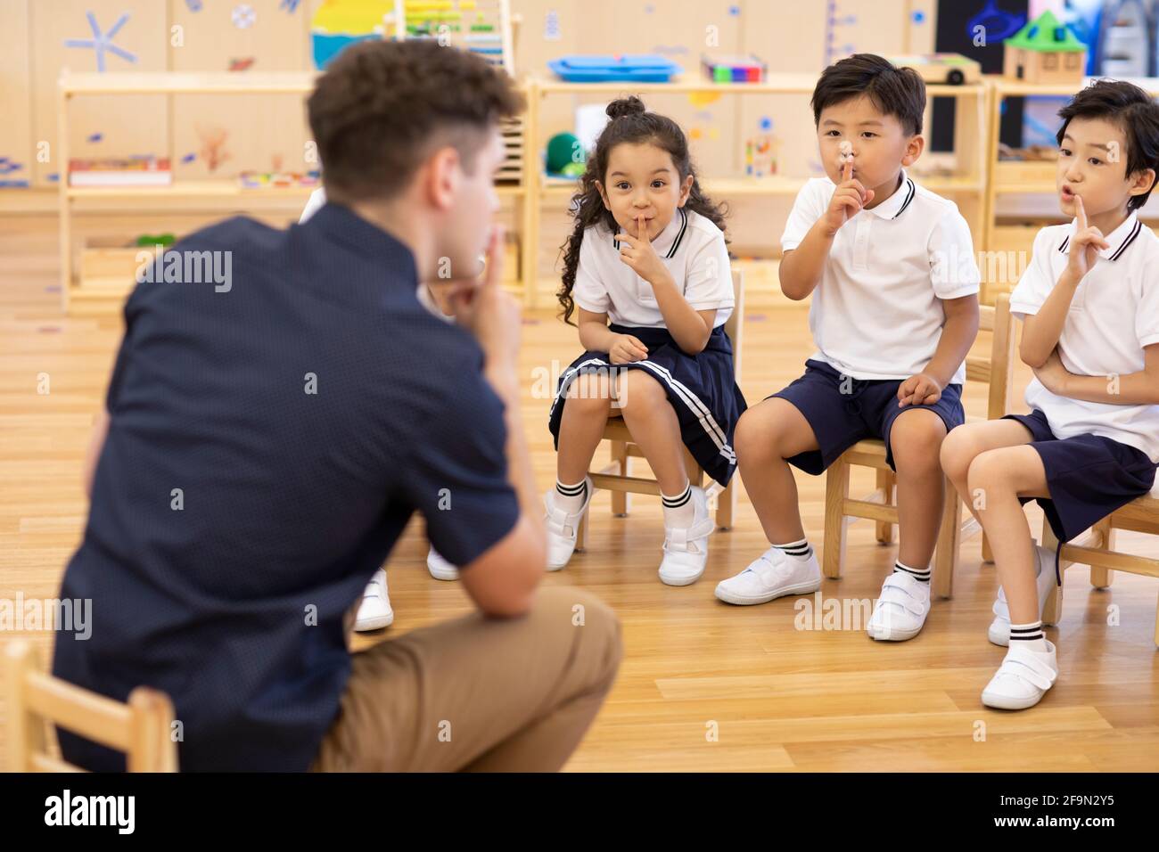 Foreign teacher and children playing games in classroom Stock Photo - Alamy