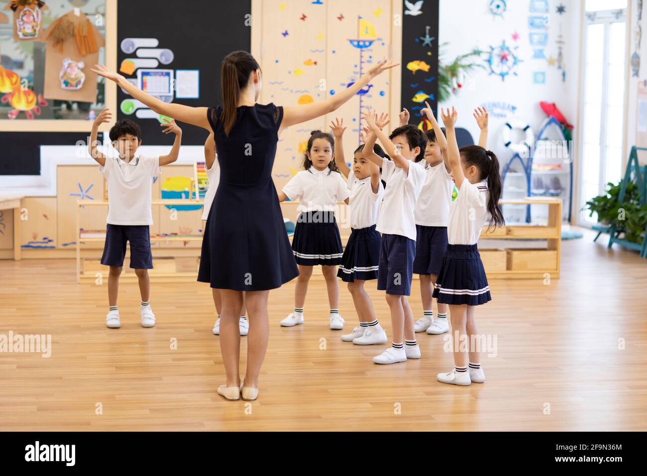 Teacher teaching children dancing in classroom Stock Photo - Alamy