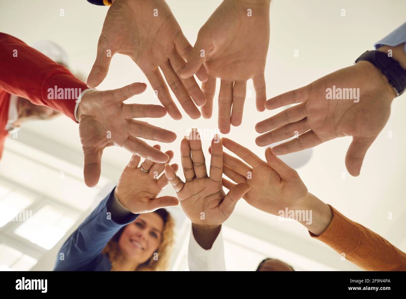 Group of people fold their hands to each other which symbolizes their unity and support. Stock Photo