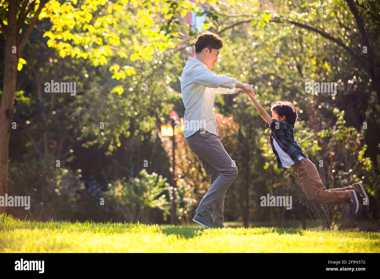 Happy father and son playing in park Stock Photo - Alamy