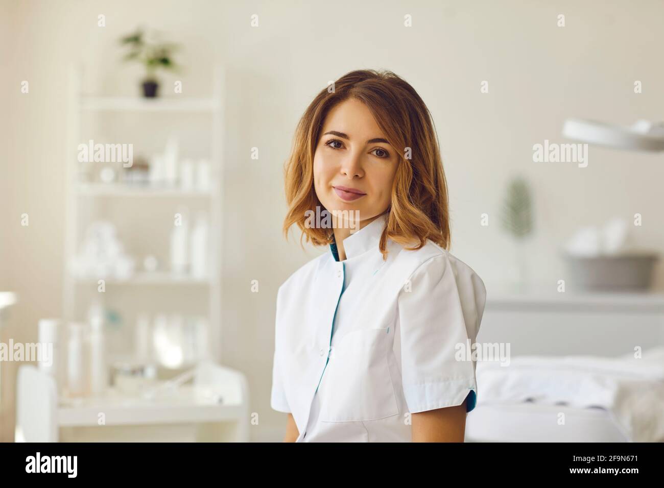 Portrait of smiling cosmetologist looking at camera on beauty spa salon Stock Photo