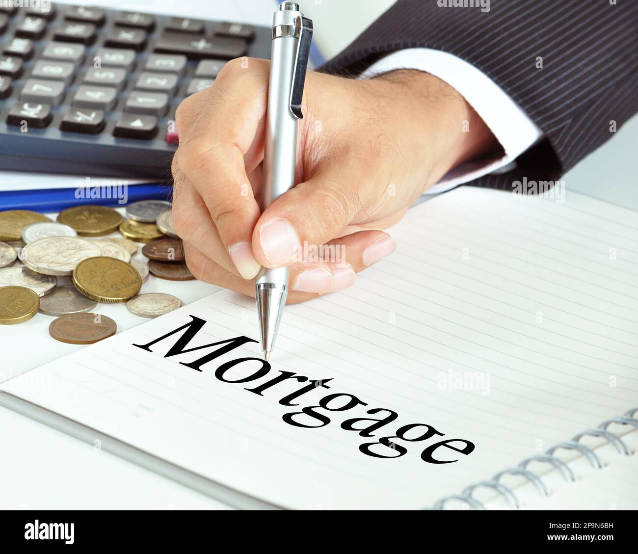 Hand with pen pointing to Mortgage word on the paper - financial & business concept Stock Photo