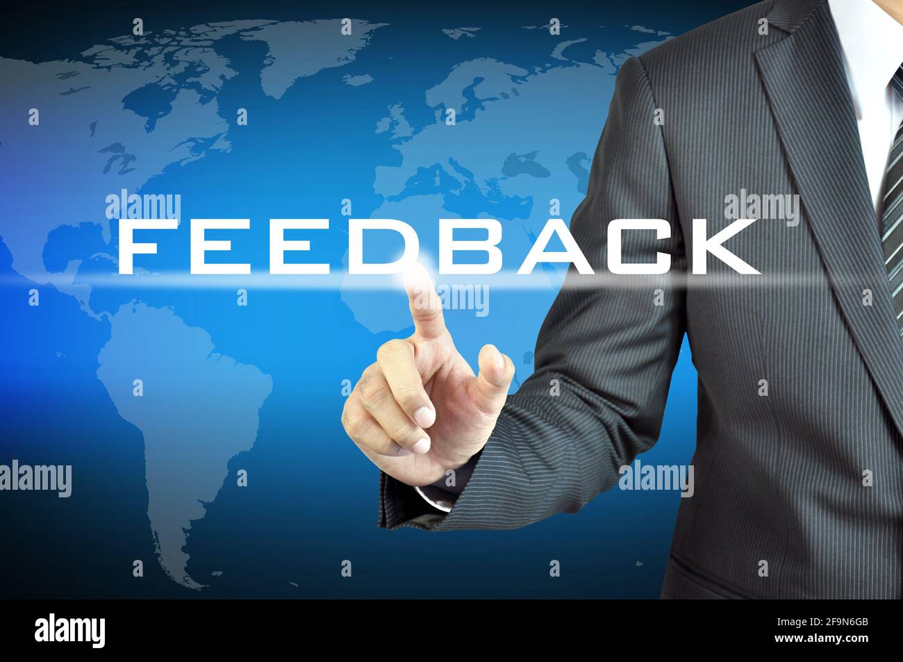 Businessman hand pointing to FEEDBACK sign on virtual screen Stock Photo
