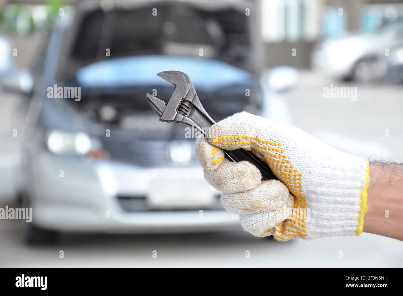 Hand holding wrench - car checking & repairing concept Stock Photo