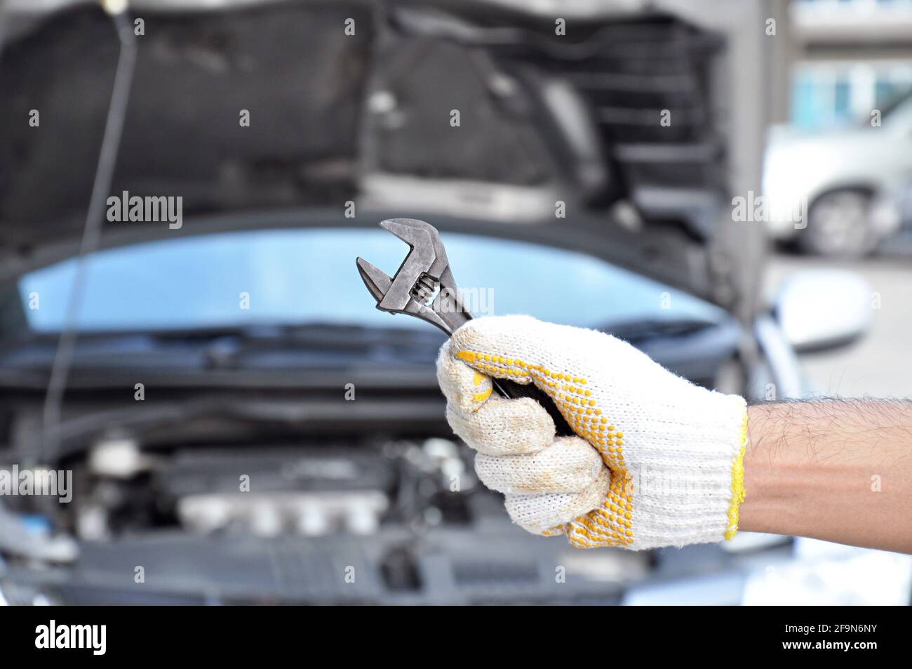 Hand holding wrench - car checking & repairing concept Stock Photo