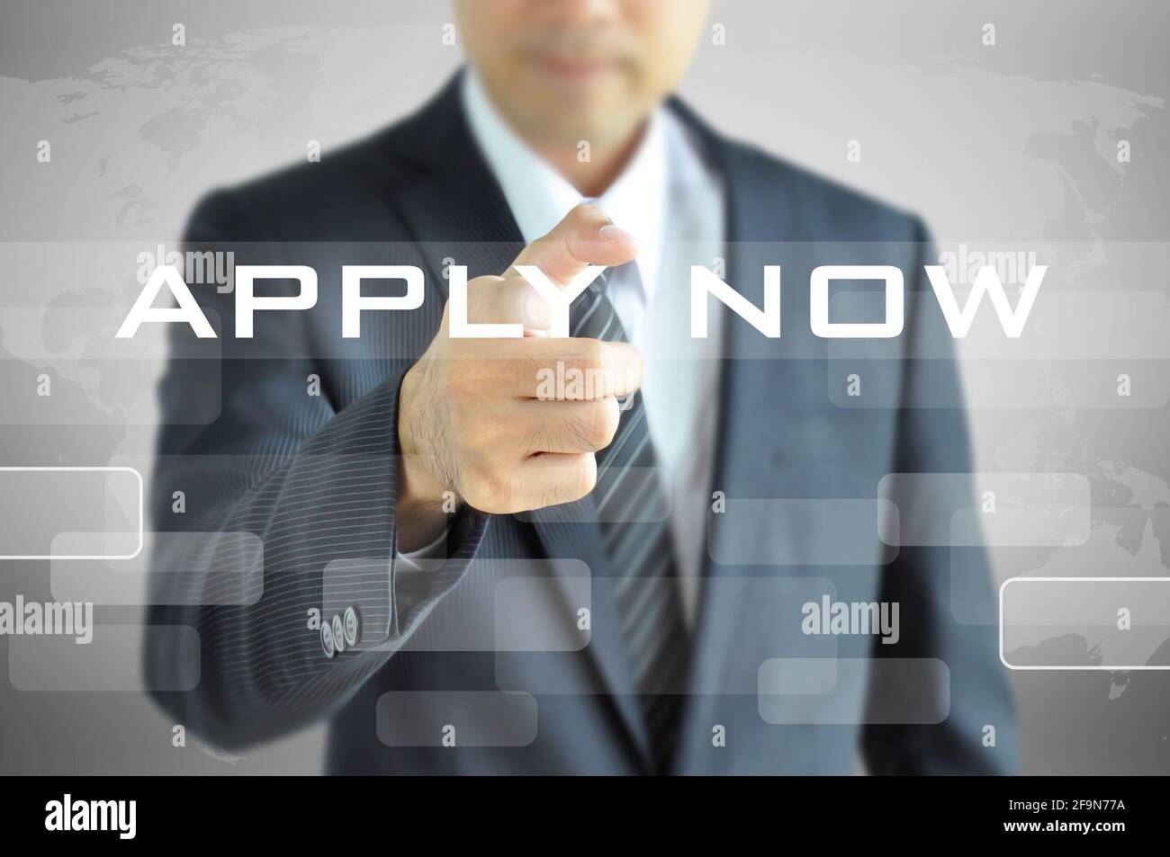Businessman hand pointing to APPLY NOW on virtual screen Stock Photo