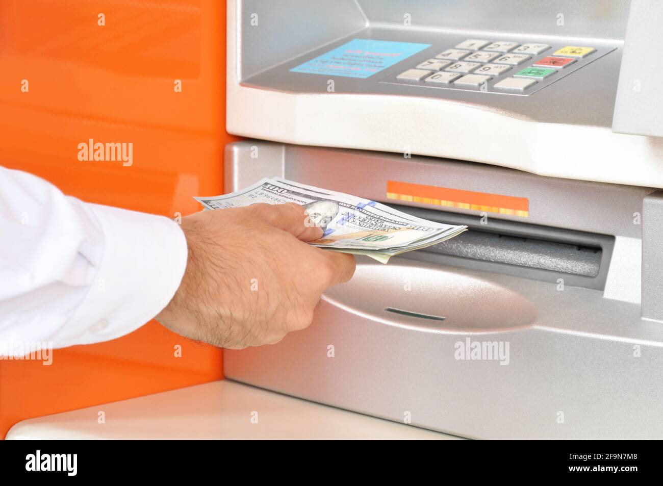 Hand taking (withdraw) money from ATM Stock Photo