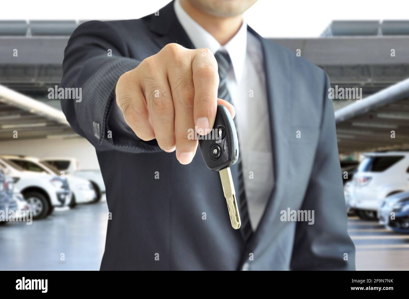 Businessman hand giving a car key - car sale & rental business concept ...