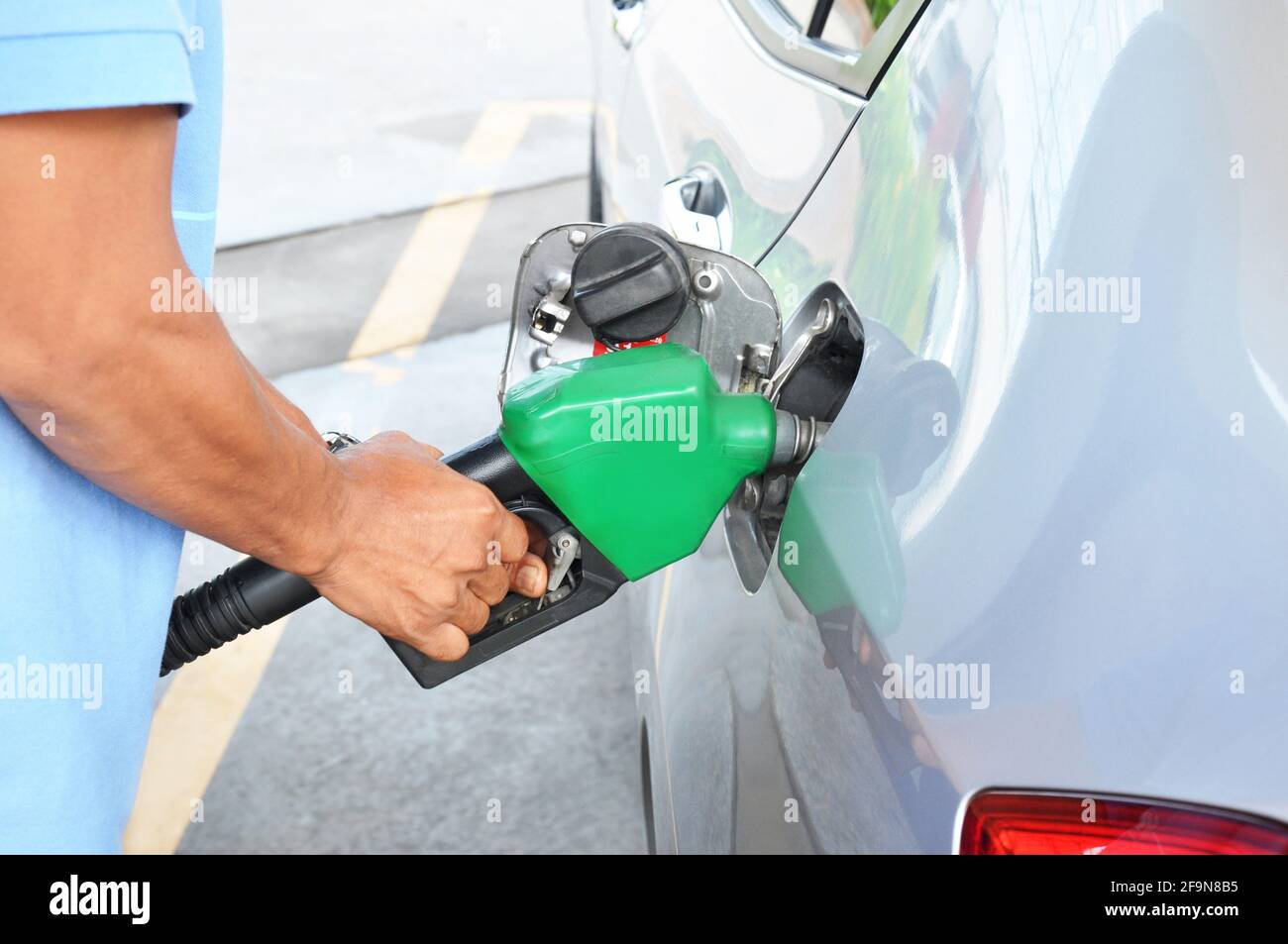 A man filling up the gas tank of a car Stock Photo