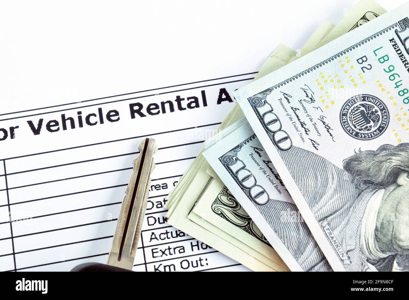 Money & car key on Vehicle Rental Agreement paper Stock Photo