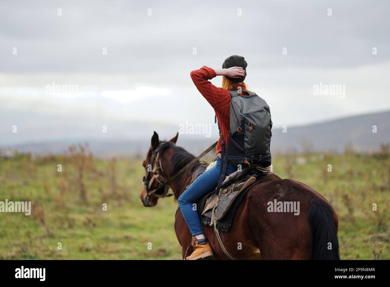 woman hiker with backpack riding horse travel freedom Stock Photo - Alamy