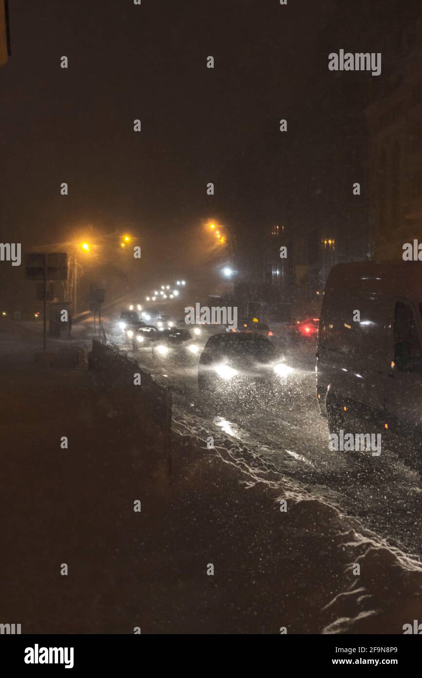 Winter snow storm. Traffic jam at night. Car blurred at the street. Stock Photo