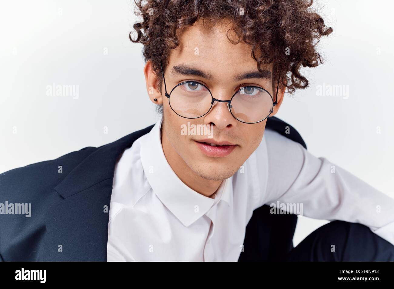 close-up portrait of handsome guy with curly hair wearing glasses and in a  classic suit Stock Photo - Alamy