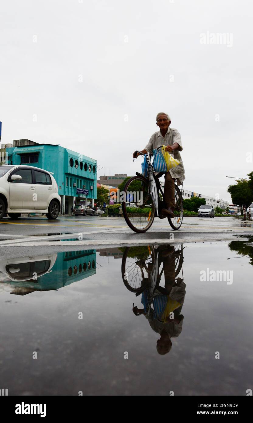 A man cycling in Miri, Malaysia. Stock Photo