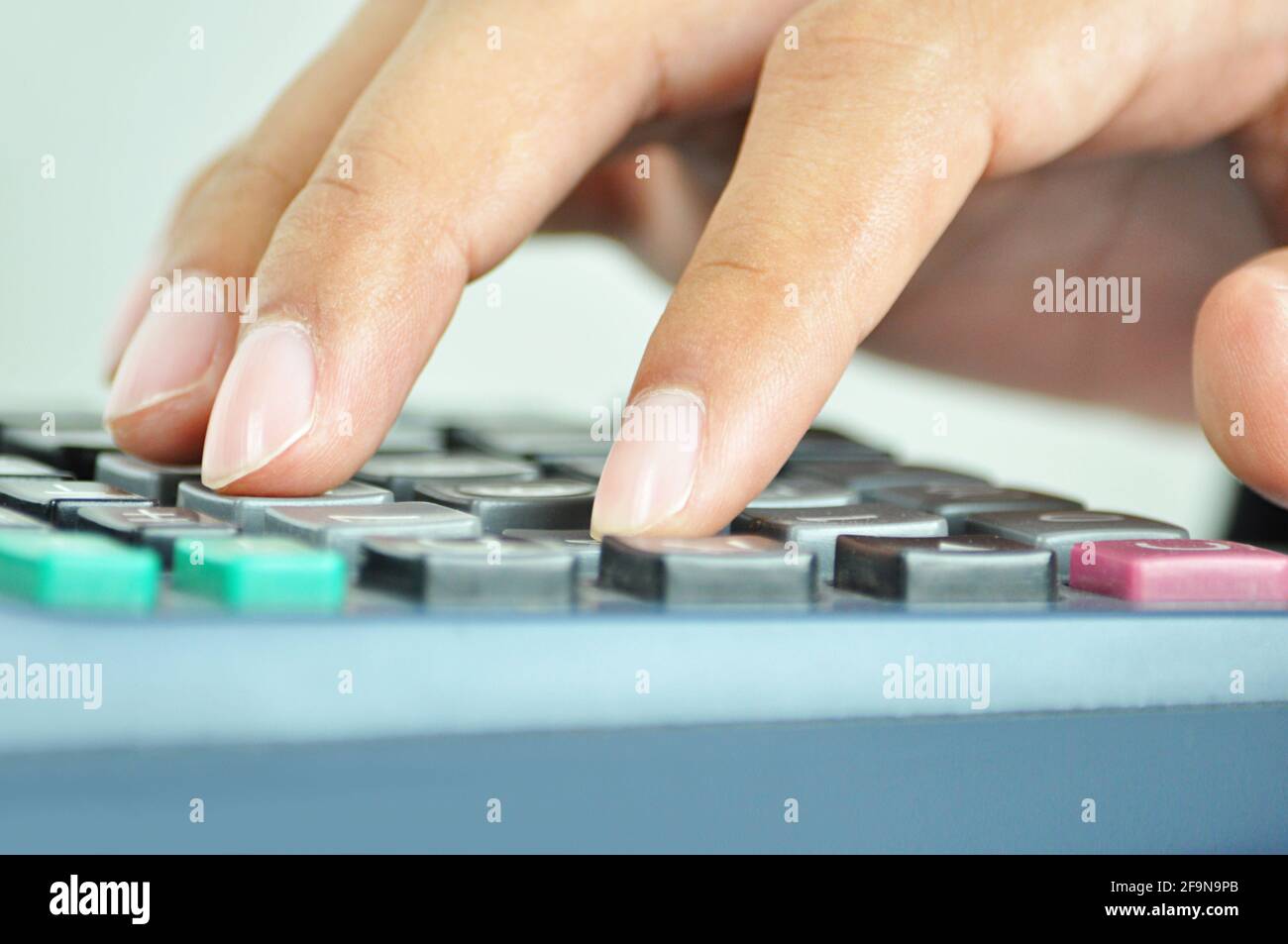 Finger pressing on calculator keypad - close up Stock Photo