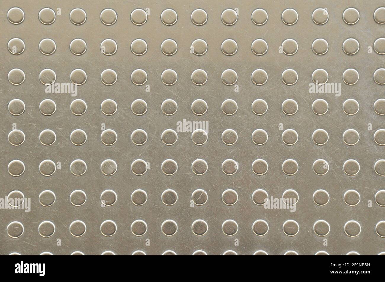 Dots on metal plate as tactile paving or signal for blind people on footpath or platform Stock Photo
