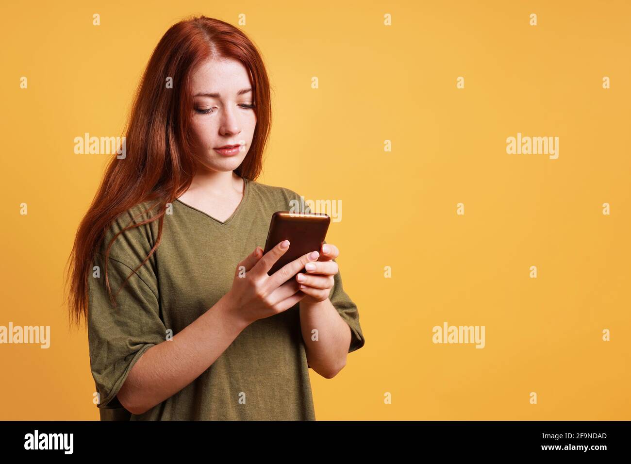 young woman reading text message on smartphone or mobile cell phone Stock Photo