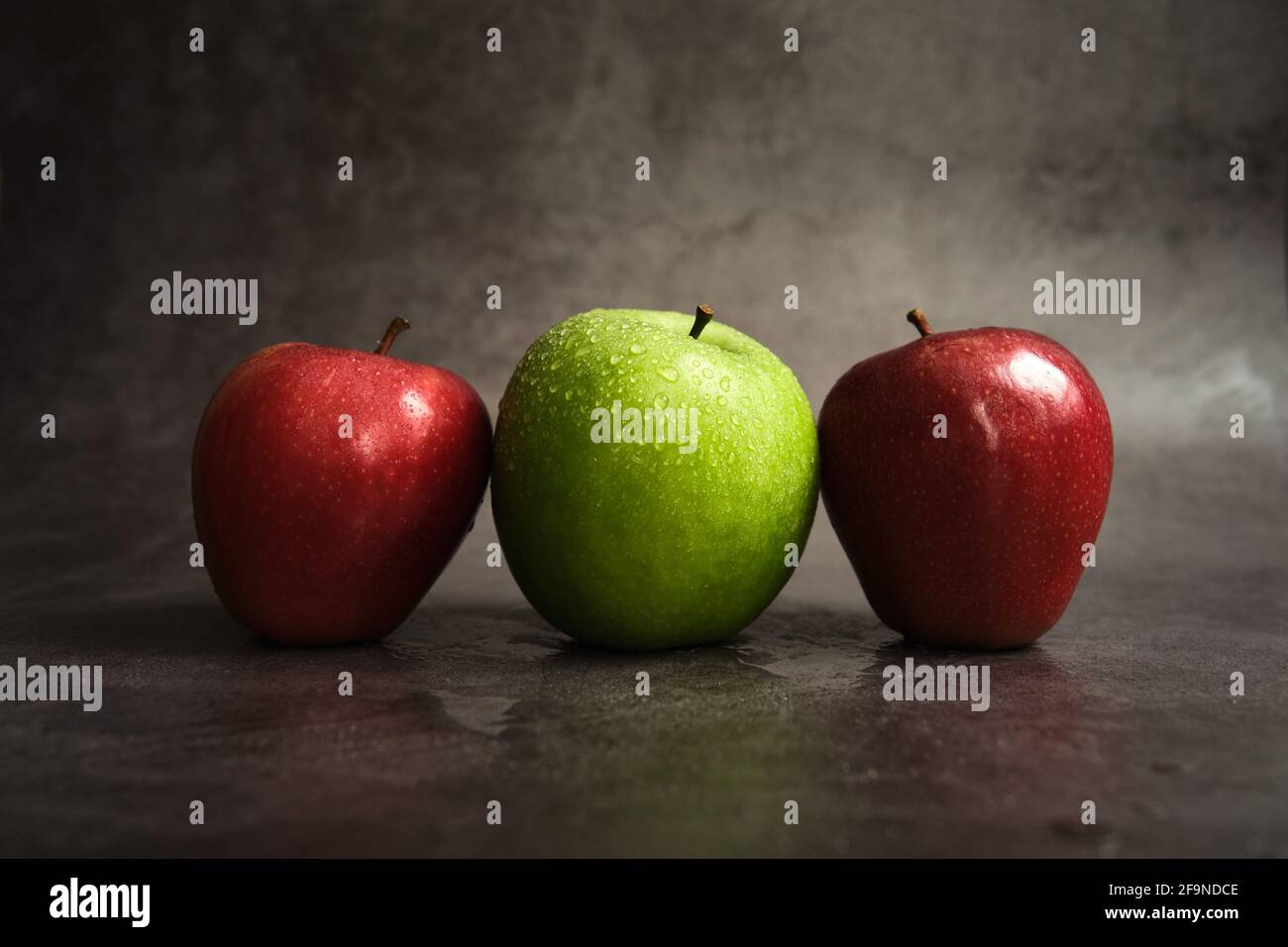 three apples on a dark background Stock Photo - Alamy