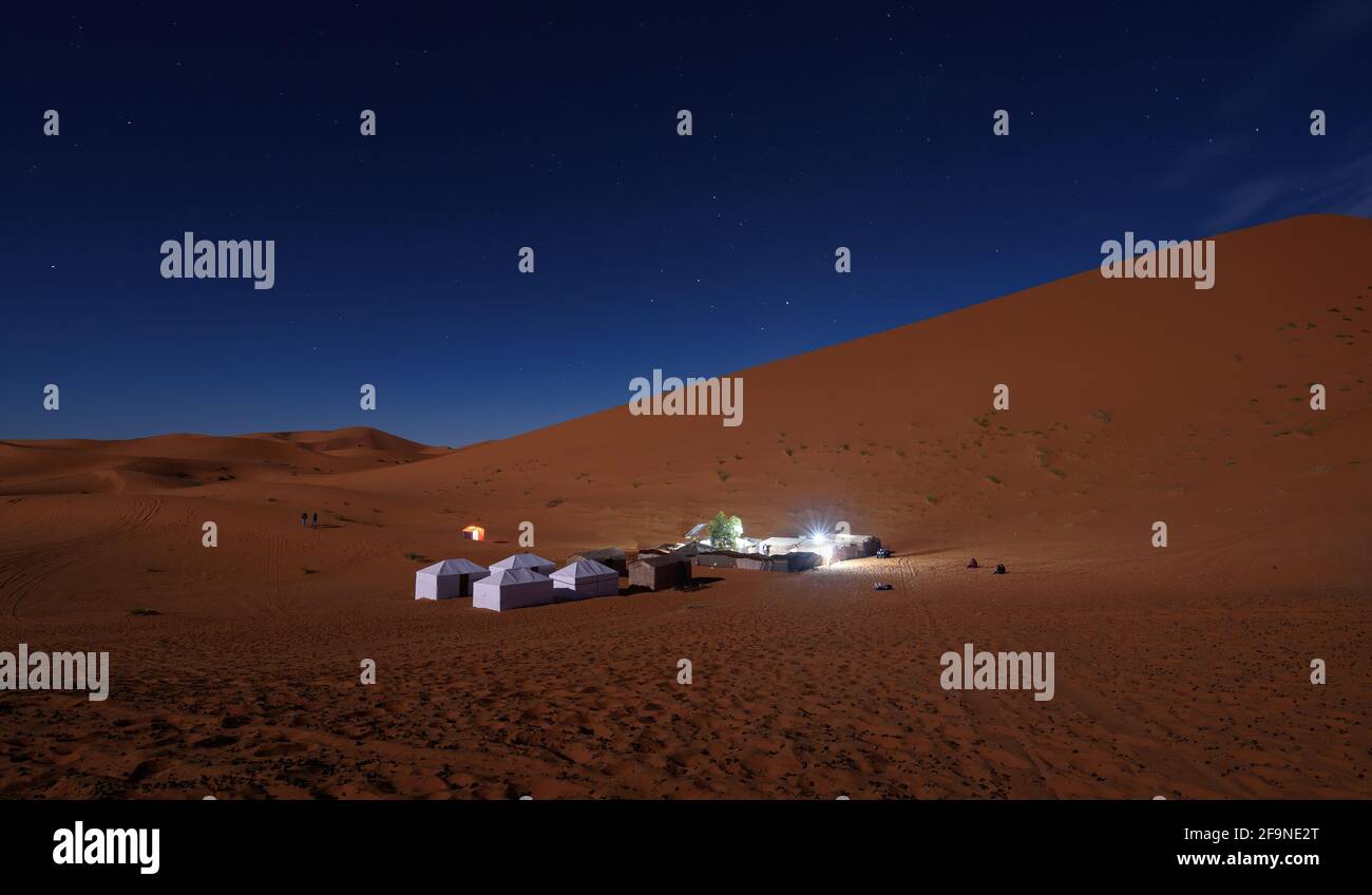 Desert camp on a sand dune in the Sahara desert during night under a ...