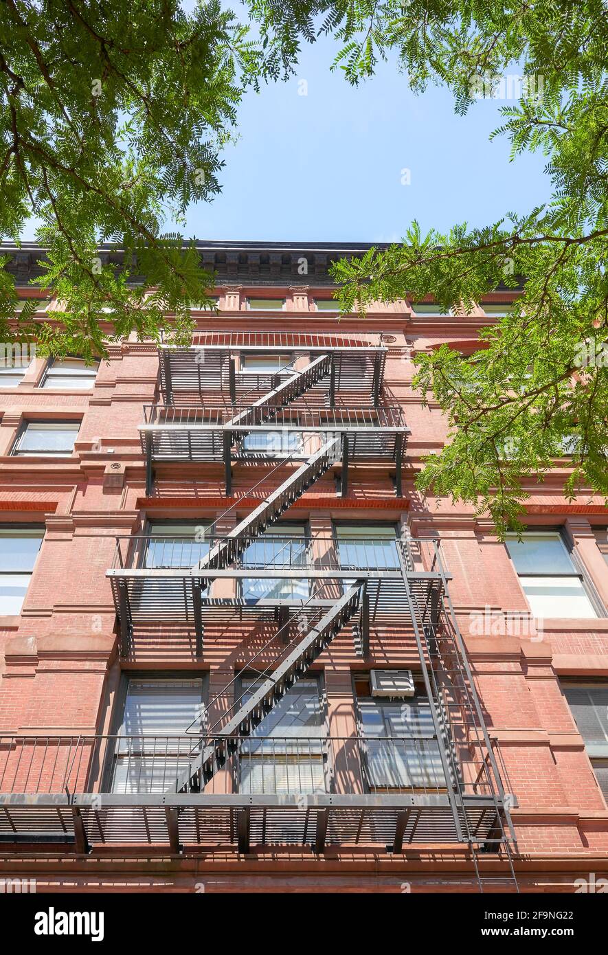 Looking up at an old red brick building with fire escape, New York City, USA. Stock Photo